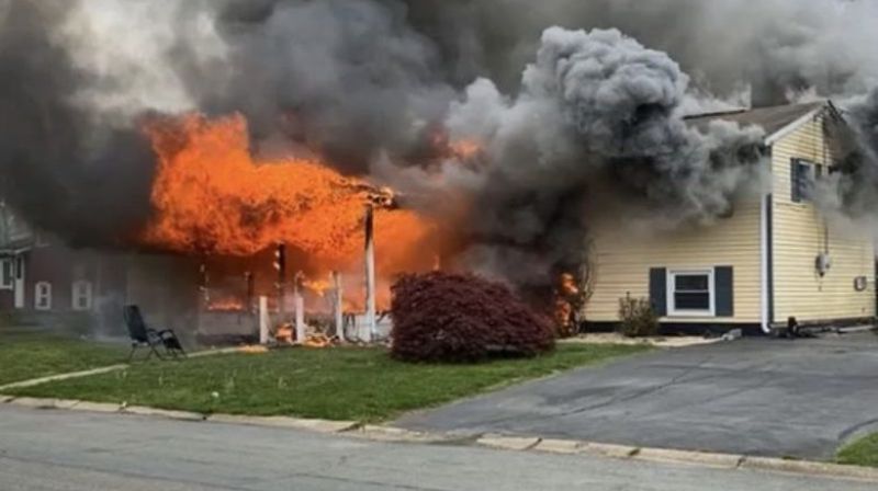 American woman sat on the lawn and watched her house burn