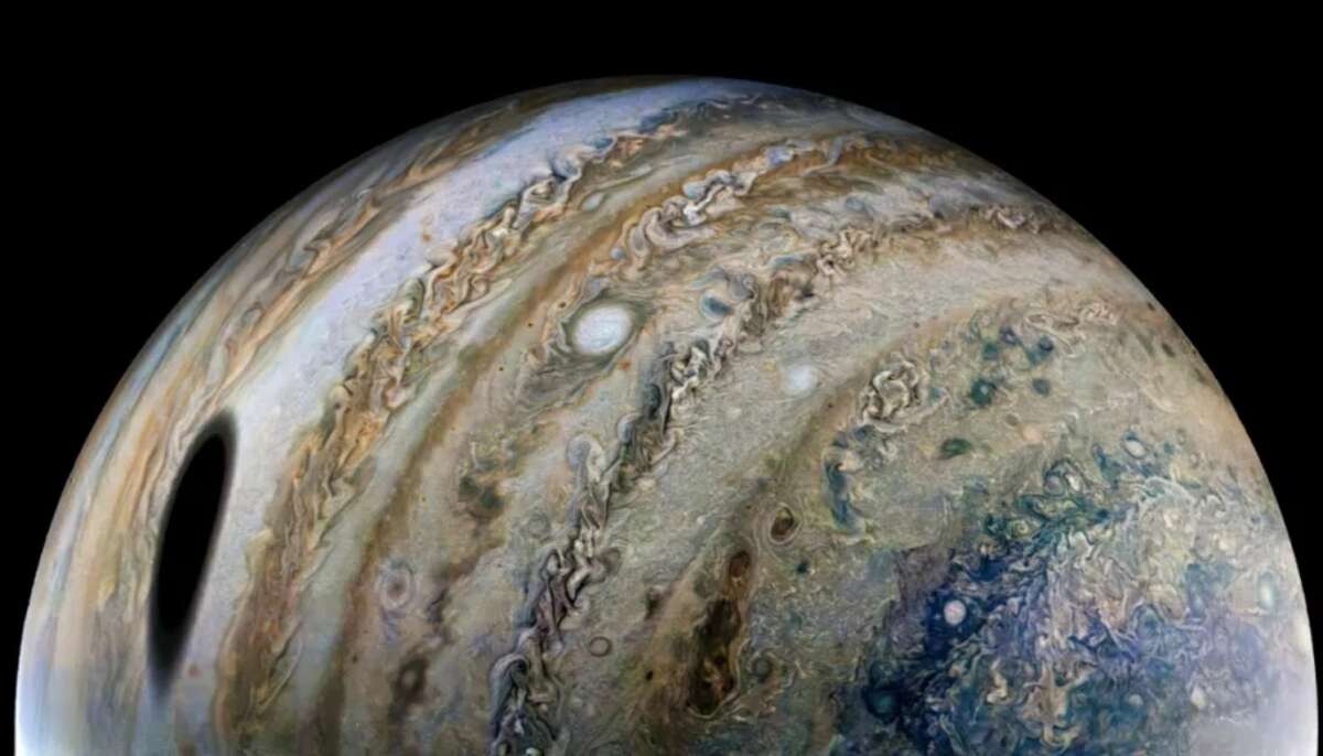 Shadow of Jupiters largest moon looms in gorgeous new Juno photo