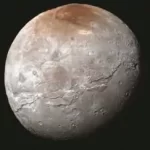 Plutos moon has a mysterious red north pole and we may finally know why